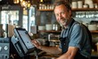 © piai - A happy restaurant businessman with the new modern POS system