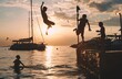 Silhouette of children jumping into the sea from an old ship dock, with ships and sailing yachts in the background. Sunset light