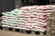 A pile of white and red bags of sand. The bags are stacked on top of each other
