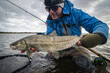 Happy angler with white fish caught on fly rod
