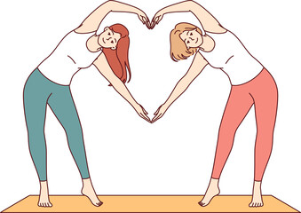 paired yoga of two women doing aerobics or pilates standing on sports mat and making heart sign from