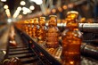 Conveyor belt full of amber glass bottles of beer in factory