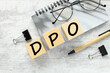 DPO wooden blocks with text. on a gray notepad near the glasses