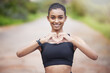 Active, woman and heart for fitness in outdoors or portrait as runner for exercise or training for race. Indian, female person and sports for cardio, health and wellness for achievement of goal