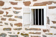 Small ventilation window with bars and shutter on colonial American stone farm building rustic architectural feature