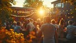 © Athena - A group of people enjoy a social evening at an outdoor venue with festive lights as the sun sets.