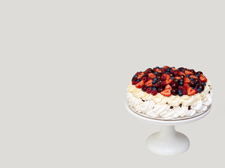 Wall Mural - Meringue Pavlova cake with whipped cream and fresh berries isolated on grey background. Horizontal orientation