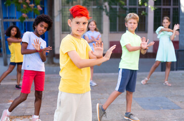 Wall Mural - Confident tween boy street dancer posing during performance with group in summer city ..