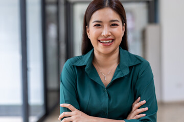 Wall Mural - Portrait of happy an Asian businesswoman sitting at her desk office business plan investment, finance analysis concept.Looking at the camera.