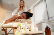Luxury spa massage Caucasian dark hair woman enjoying massage, laying on the table covered with a towel