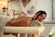 Attractive Caucasian dark hair woman enjoying massage, laying on the table covered with a towel