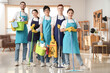 © Pixel-Shot - Group of young janitors with cleaning supplies in office