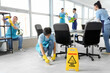 © Pixel-Shot - Team of young janitors cleaning in office