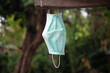 Blue surgical mask hanging on the wooden wall in the garden. Health care concept.