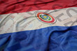 waving colorful national flag of paraguay on a euro money banknotes background. finance concept.