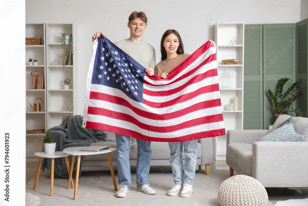 Young couple with flag of USA at home