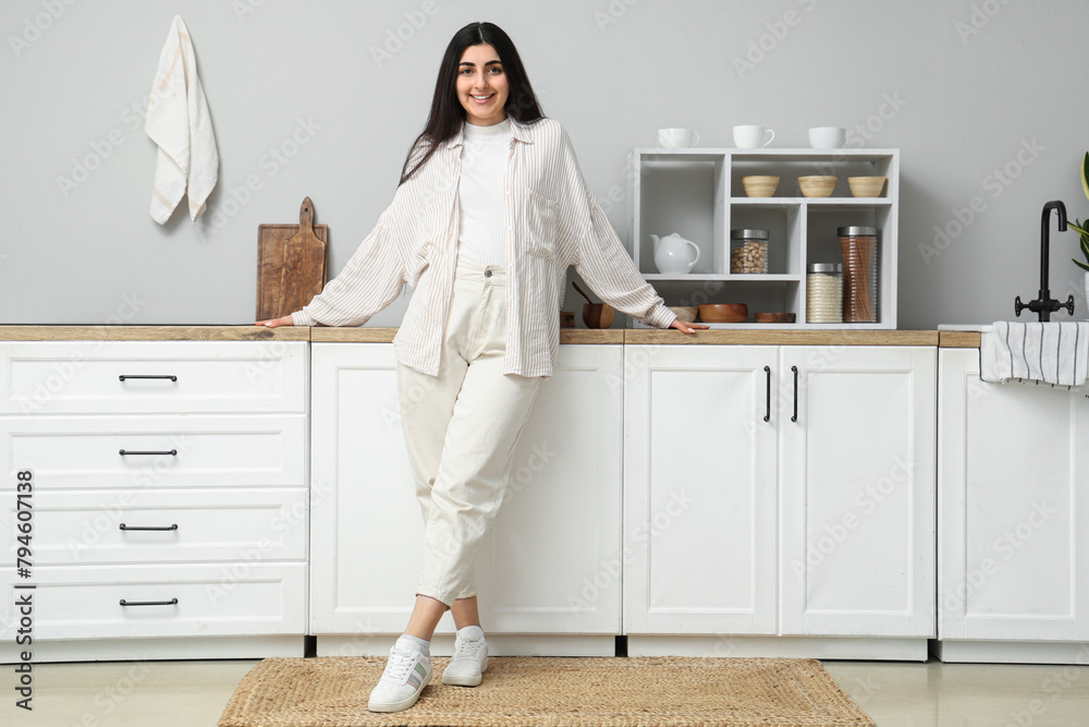 Beautiful young happy woman in kitchen at home