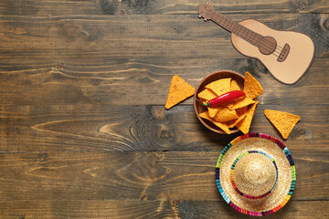 Poster - Mexican sombrero with nachos and paper ukulele on wooden background. Cinco de Mayo