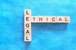 Ethical versus legal concept. Crossword puzzle flat lay in blue background.