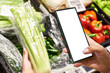 Celery vegetable in hand and smartphone isolated white