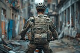 Fototapeta Las - A military man in a bulletproof vest and helmet rides a bicycle. The concept of the army's poverty, insufficient equipment for soldiers.