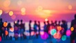 © tashechka - Colorful, abstract blur of a crowd enjoying a beach sunset party with vibrant bokeh effect.