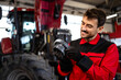 Professional mechanic servicing tractor gears transmission inside workshop.