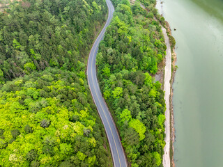 Wall Mural - Aerial photography of the winding mountain road by the river