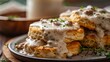 Appetizing Southern biscuits smothered in creamy sausage gravy, ideal for a gourmet food advertisement, on an isolated backdrop