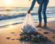 A woman picking up litter on the beach