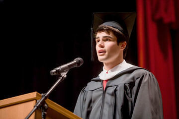 Wall Mural - At a festive event, the graduate delivers a speech, emphasizing the significance of education and inspiring peers to achieve their own goals