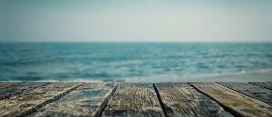 Wall Mural - front view of empty raw wooden plank old table with blurred horizon ocean beach and cloudy blue sky background