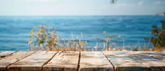 Wall Mural - front view of empty raw wooden plank old table with blurred horizon ocean beach and cloudy blue sky background 