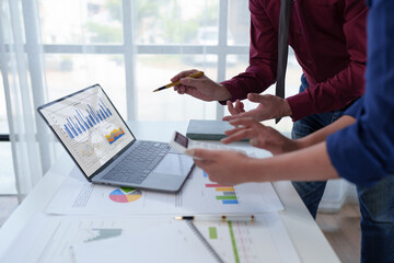 Wall Mural - Businesspeople teamwork discussing brainstorming and calculating with calculator on evaluation data in conference room Focus on business growth and point out financial accounting charts.