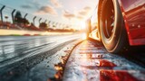 Red sports car on wet racetrack at sunset, close-up tire