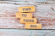 Business and Time to think big concept. Time to think big symbol on wooden blocks on old boards