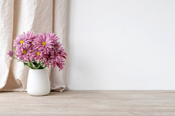 Wall Mural - Empty beige wooden table and white concrete wall surface, vase with pink flowers bouquet, linen curtain background. Podium backdrop template for product placement, blank copy space