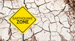 Caution Earthquake Zone Sign on Cracked Rock Background