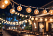 Blurred background of restaurant with abstract bokeh light. Lights decoration Party Event Festival Holiday blur background. outdoor string lights