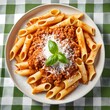 Succulent Italian pasta dish with bolognese sauce on a green and white checkered tablecloth