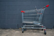 Shoping trolley against grey brick wall