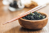 Fototapeta Lawenda - Dried wakame seaweed in bowl on wooden table.