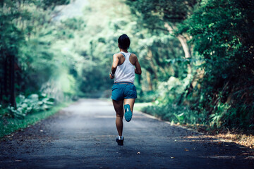 Poster - Fitness sportswoman runner running on tropical forest trail