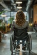 © Viewvie - Rear view of young woman in wheelchair in corridor of modern office