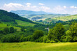 picturesque landscape of the rural valley and farmland scenery of ukraine. village and mountains in the distance. bright sunny weather in summer