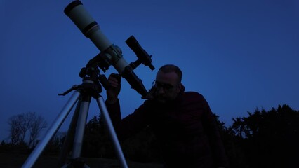 Wall Mural - amateur astronomer looking at the evening skies, observing planets, stars, moon and other celestial 