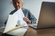 senior elderly woman  checking bills and tax on desktop at home retired 