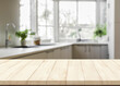 Wooden table top with blurred modern kitchen