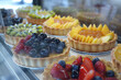 Elegant display of gourmet fruit tarts and savory quiches in a high-end patisserie, with a focus on the flaky crusts and vibrant fillings