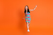 Full size photo of funky positive woman wear flower print dress dancing celebrate black friday isolated on orange color background